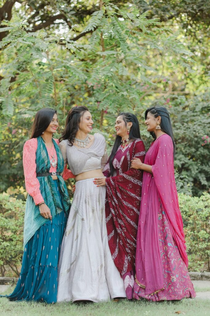 Group of women in colorful Indian traditional clothing outdoors, showcasing elegance and friendship.